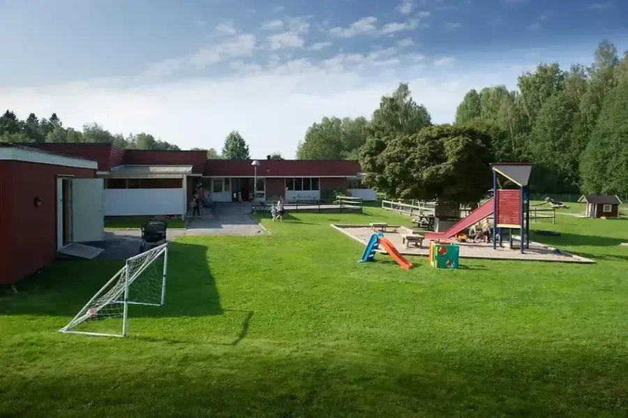 Förskola med utegård. På utegården finns en lekställning med rutschkana